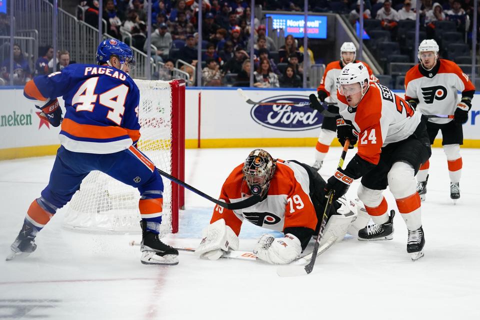 Philadelphia Flyers goaltender Carter Hart (79) stops a shot by New York Islanders' Jean-Gabriel Pageau (44) as Flyers Nick Seeler (24) watches during the second period of an NHL hockey game Wednesday, Nov. 22, 2023, in Elmont, N.Y. (AP Photo/Frank Franklin II)