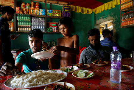 Azimul Hasan, 10, a Rohingya refugee boy, serves plates at a roadside hotel where he works at Jamtoli, close to Palong Khali camp, near Cox's Bazar, Bangladesh, November 12, 2017. REUTERS/Navesh Chitrakar