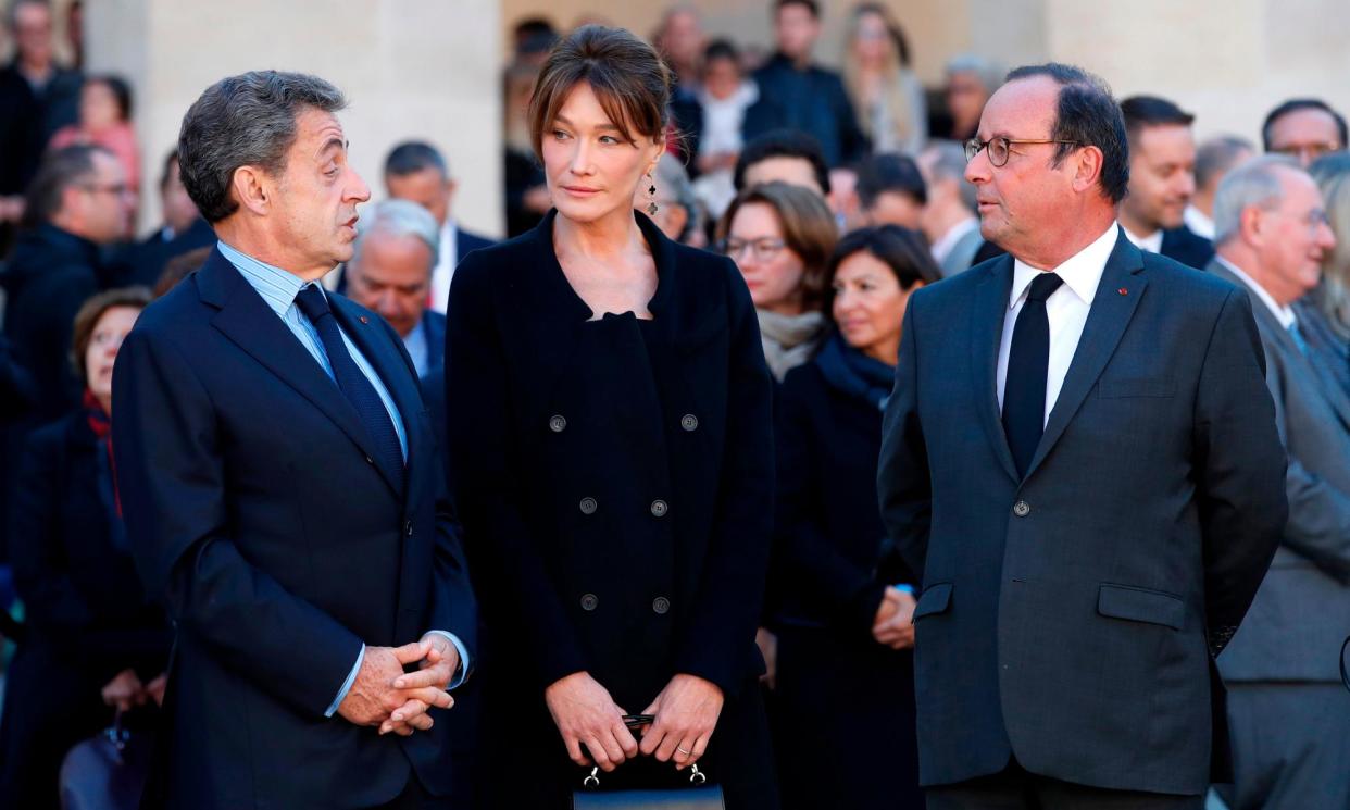 <span>Nicolas Sarkozy, left, his wife, Carla Bruni, and François Hollande attend a ceremony of national homage to the singer Charles Aznavour in Paris in 2018.</span><span>Photograph: Christophe Ena/AFP/Getty Images</span>