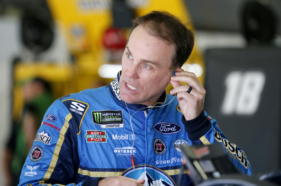 FILE - In this July 21, 2018, file photo, driver Kevin Harvick puts in an ear piece as he prepares for practice for the NASCAR Cup Series auto race at New Hampshire Motor Speedway in Loudon, N.H. Harvick's bid for a second NASCAR title suffered a massive setback when he was stripped of his berth in the championship race after series inspectors found his winning car from Texas Motor Speedway had been deliberately altered to give him a performance advantage. (AP Photo/Mary Schwalm, File)