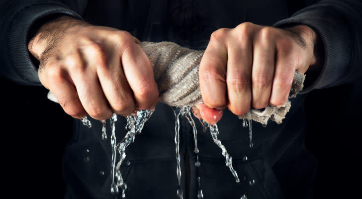Man squeezing water out of a rag representing FNGR stock. Short Squeeze Stocks