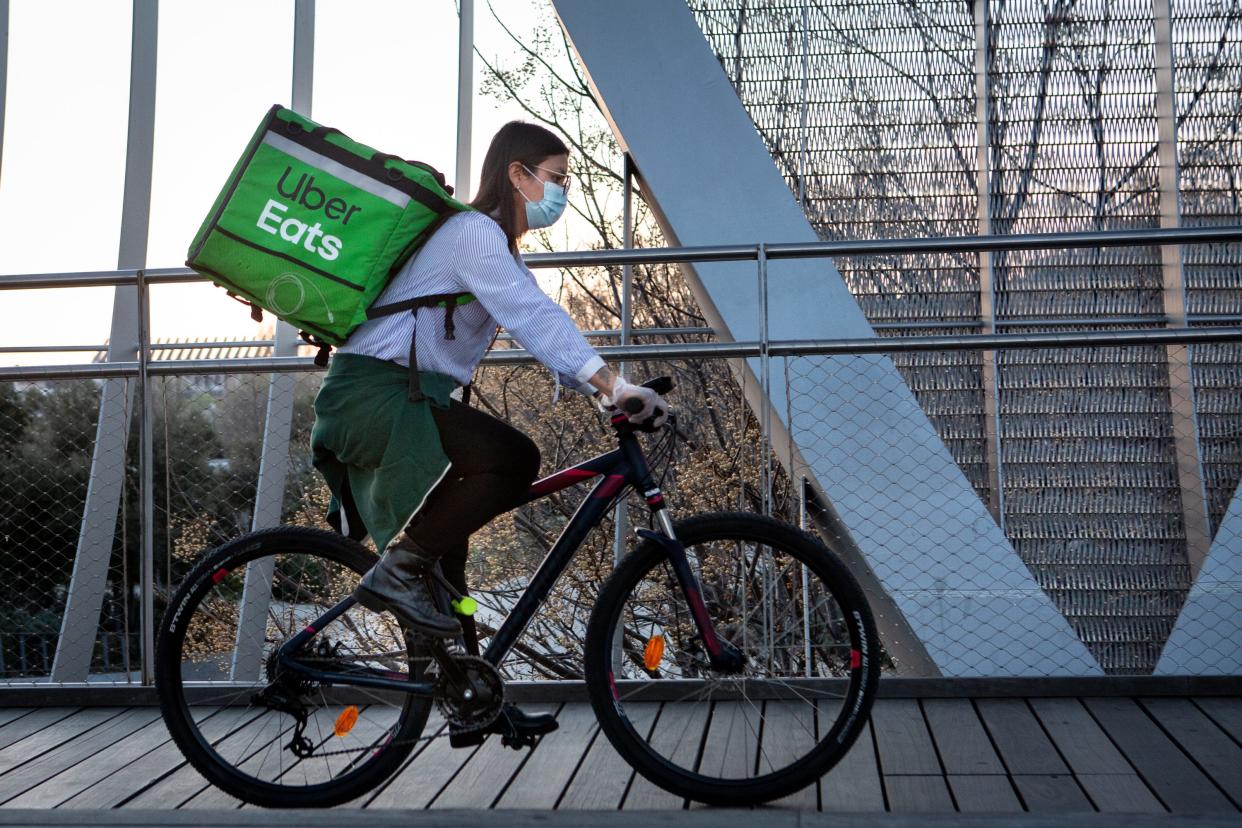 An Uber Eats delivery bike rider wears face mask as a precaution against transmission of the coronavirus at Madrid Rio park on March 14, 2020 in Madrid, Spain. Today known cases of Covid-19 in Madrid are 2,940, while there are 86 reported deaths. The cases in Spain are 5,867 people infected of coronavirus and 135 deaths. The Spanish Government has declared the state of emergency to contain the spread of the virus. All businesses which are not of prime interest, such as grocery stores and pharmacies will have to close temporarily.