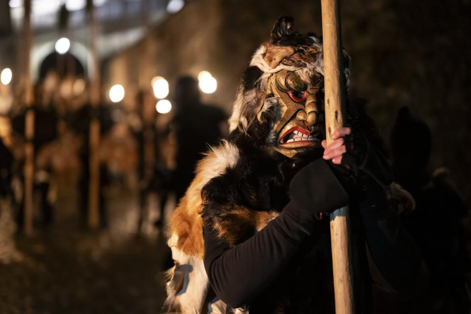 The Anfuehrer equipped with long-handled juniper broom and scary wooden mask, pictured prior the 100th traditional ‘Achetringele’ procession, in Laupen, Switzerland (EPA)