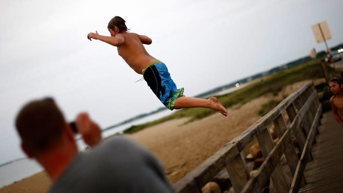 A young boy jumps from the American Legion Memorial Bridge near State Beach on the road between Oak Bluffs and Edgartown in Oak Bluffs, Massachusetts, on the island of Martha’s Vineyard. A man is dead and his brother remains missing after jumping from the bridge late Sunday night. (Photo: Win McNamee/Getty Images)