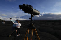 Jason, left, and Anakaren Pagan, of Memphis, take a picture near the Mauna Loa volcano as it erupts Wednesday, Nov. 30, 2022, near Hilo, Hawaii. (AP Photo/Gregory Bull)