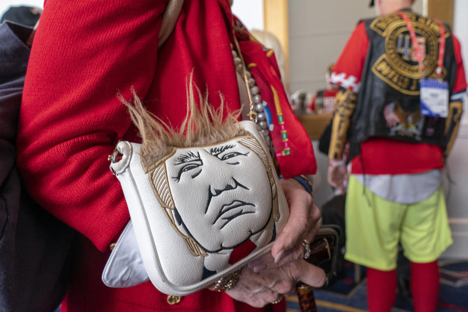 A supporter holds a purse with a likeness of former President Donald Trump at the Conservative Political Action Conference, CPAC 2023, Saturday, March 4, 2023, at National Harbor in Oxon Hill, Md. (AP Photo/Alex Brandon)