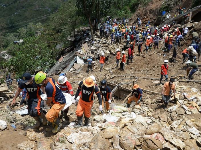 Rescuers carry a body bag containing the body of a victim of a landslide during heavy rains at the height of Typhoon Mangkhut in Itogon town (AFP Photo/TED ALJIBE)