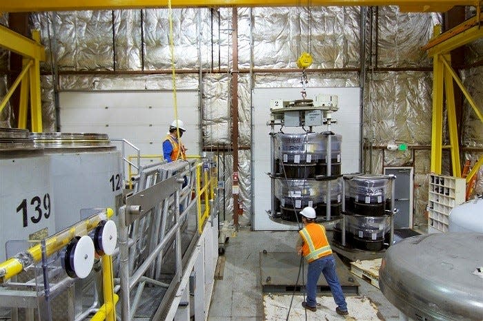 Crews at the Idaho National Laboratory Site prepare to load certified transuranic waste into a TRUPACT-II container for shipping to the Waste Isolation Pilot Plant.