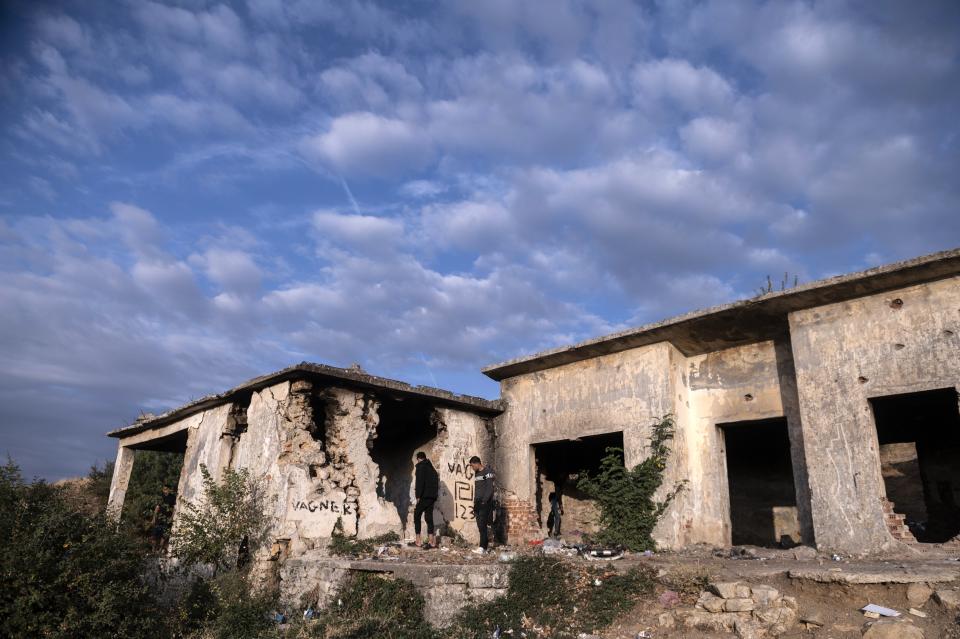 Migrants enter an abandoned army outpost near Ieropigi village, northern Greece, at the Greek - Albanian border, on Tuesday, Sept. 28, 2021. A relatively smooth section of Greece's rugged border with Albania is turning into a major thoroughfare north for migrants in Greece seeking a better life in Europe's prosperous heartland. (AP Photo/Giannis Papanikos)