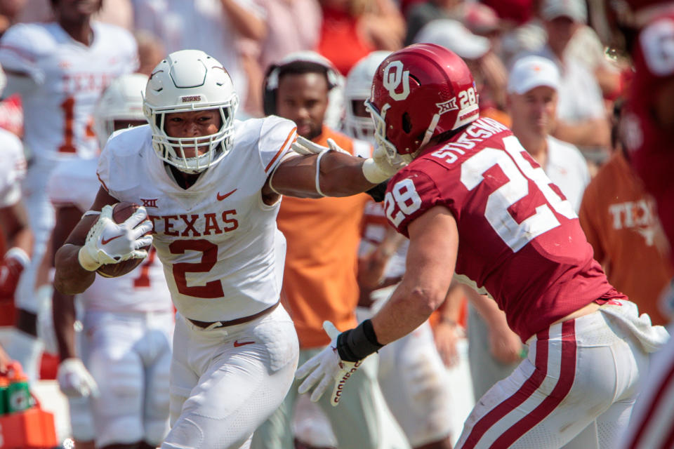 DALLAS, TX - OCTOBER 08: Texas Longhorns running back Roschon Johnson (2) stuff arms Oklahoma Sooners linebacker Danny Stutsman (28) during the second half on October 8th 2022 at the Cotton Bowl Stadium in Dallas Texas. (Photo by William Purnell/Icon Sportswire via Getty Images)