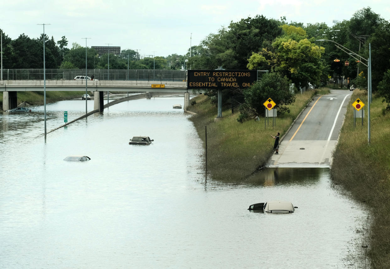 Detroit residents on June 28 observe a stretch of I-94 that is still under several feet of water following heavy weekend rains which flooded parts of Metro Detroit. (Matthew Hatcher/SOPA Images/LightRocket via Getty Images)