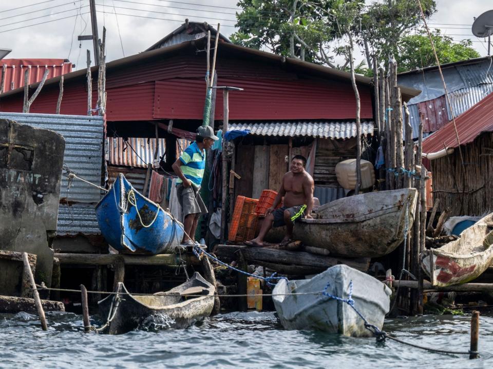 Guna men talk as they sit among boats on the island of Carti Sugtupu.