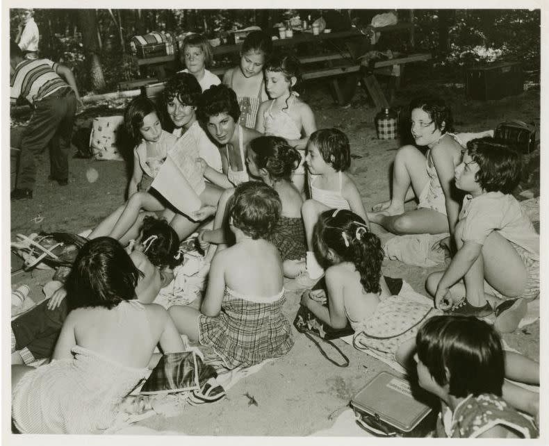 Young woman reading to girls at country camp, circa 1950, from the National Jewish Welfare Board Records.