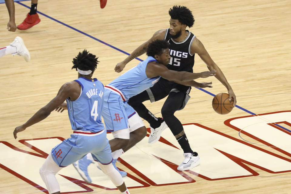 Houston Rockets forward Jae'Sean Tate steals the ball from Sacramento Kings' Marvin Bagley during the first half of an NBA basketball game Thursday Dec. 31, 2020, in Houston. (AP Photo/Richard Carson)