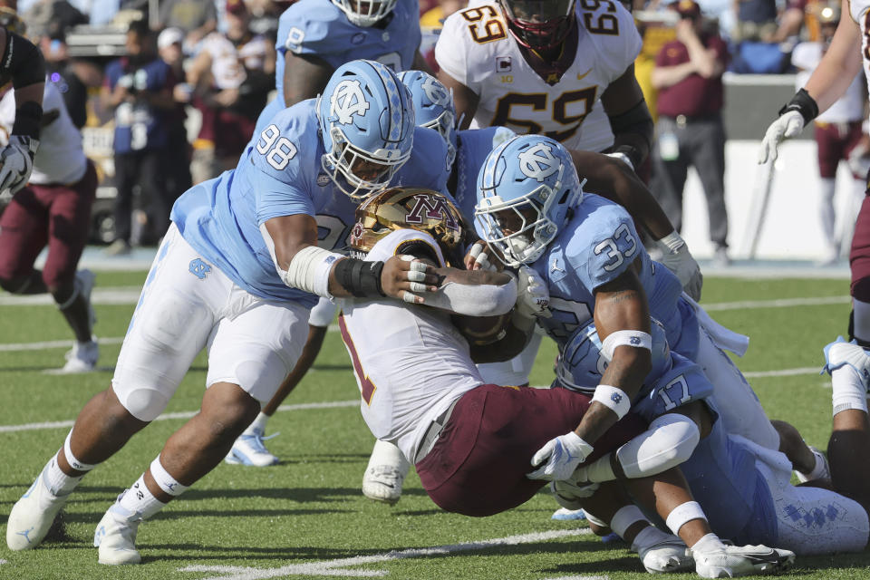 Minnesota running back Darius Taylor (1) is tackled by ]North Carolina defensive lineman Kevin Hester Jr. (98) and linebacker Cedric Gray (33) during the second quarter of an NCAA college football game, Saturday, Sept. 16, 2023, in Chapel Hill, N.C. (AP Photo/Reinhold Matay)