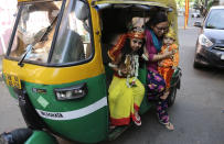 <p>An Indian woman gets down from an auto rickshaw with her children dressed as Hindu Lord Krishna to participate in the Janmashtami festivities in Kolkata, India, Aug. 25, 2016. Janmashtami marks the birth of Lord Krishna. (Photo: Bikas Das/AP) </p>