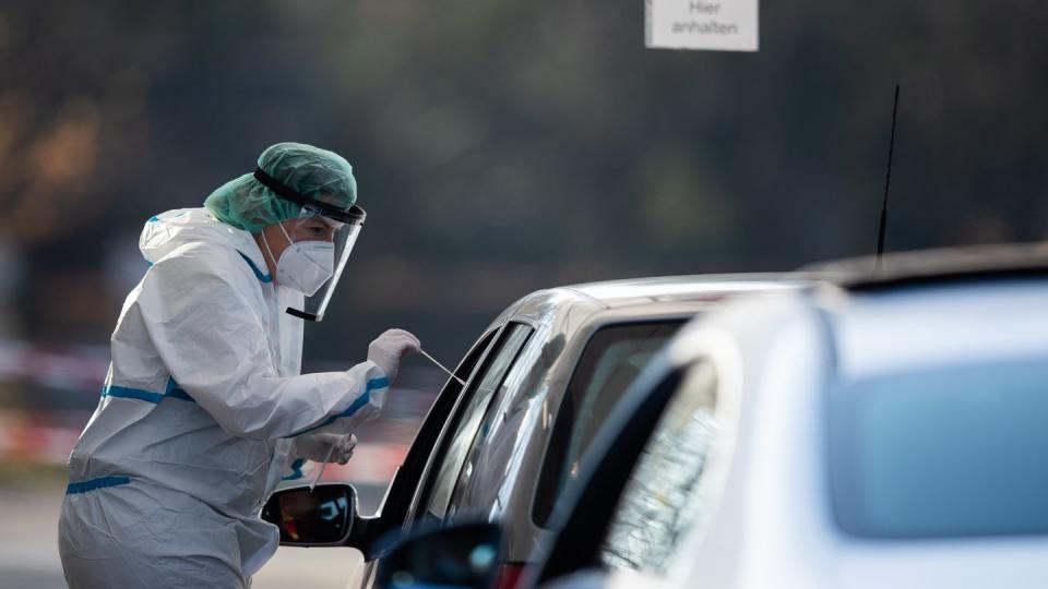 Eine medizinische Mitarbeiterin macht bei einem Autofahrer in Nürtingen einen Corona-Test.