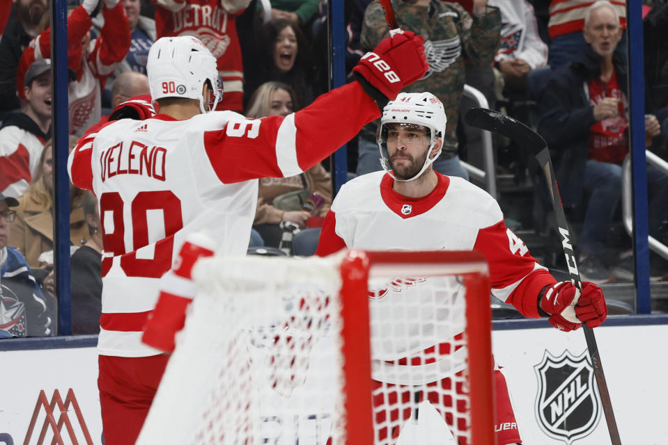 Detroit Red Wings' Shayne Gostisbehere, right, celebrate after his goal against the Columbus Blue Jackets with teammate Joe Veleno during the first period of an NHL hockey game Monday, Oct. 16, 2023, in Columbus, Ohio. (AP Photo/Jay LaPrete)