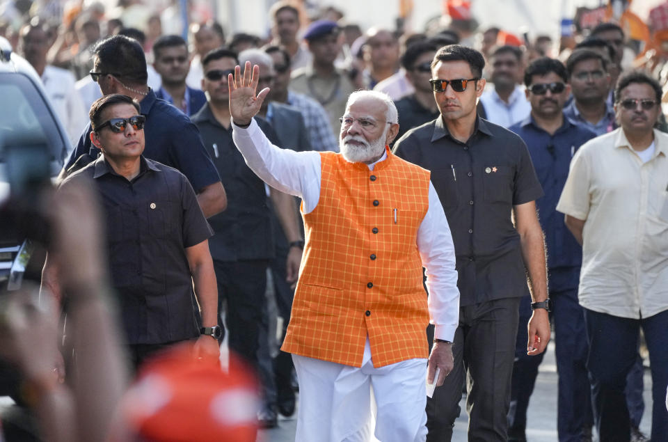 Indian Prime Minister Narendra Modi waves to people as he arrives to cast his vote during the third phase of general elections, in Ahmedabad, India, Tuesday, May 7, 2024. (AP Photo/Ajit Solanki)