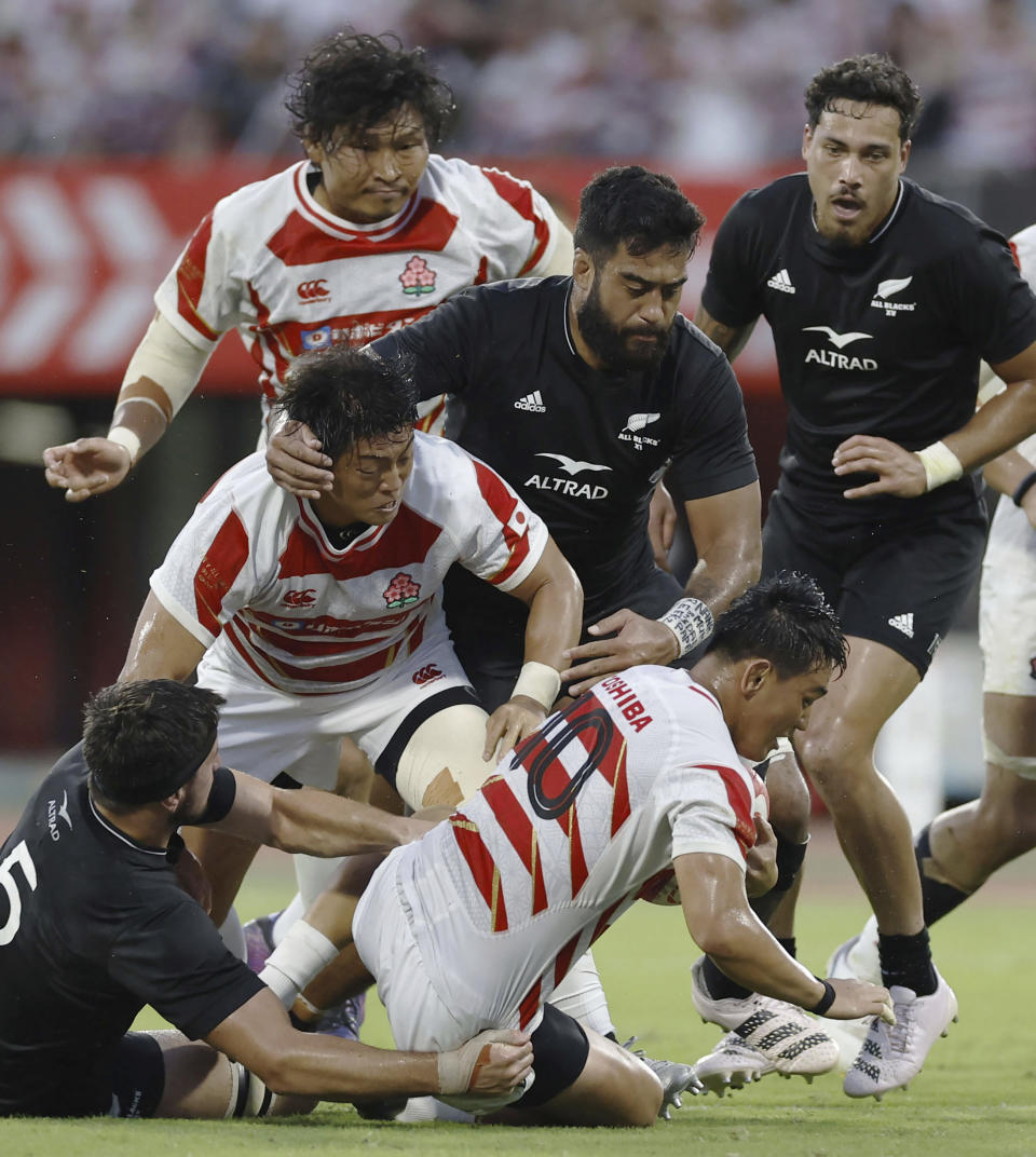 Japan's Lee Seungsin, bottom right, is tackled by All Blacks XV's Quinten Strange, left, and Akira Ioane, middle right, during their Challenge Cup rugby match in Kumamoto, western Japan, Saturday, July 15, 2023. (Kota Endo/Kyodo News via AP)