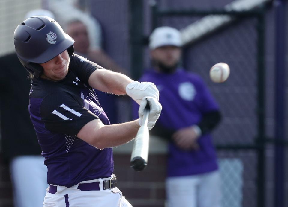 Jackson's Travis Feucht hits a sacrifice fly to drive in a runner against Twinsburg in the first inning of their baseball game at Jackson High School on Friday April 23, 2021. Jackson beat Twinsburg 9-4.