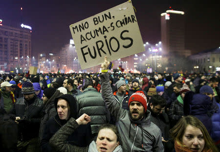 A protestor holds a sign reading "Ok, now I am really angry" during a demonstration in front of the government office in Bucharest, Romania, February 1, 2017. Inquam Photos/Octav Ganea via REUTERS