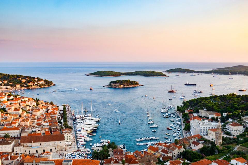 high angle view of townscape by sea against sky during sunset