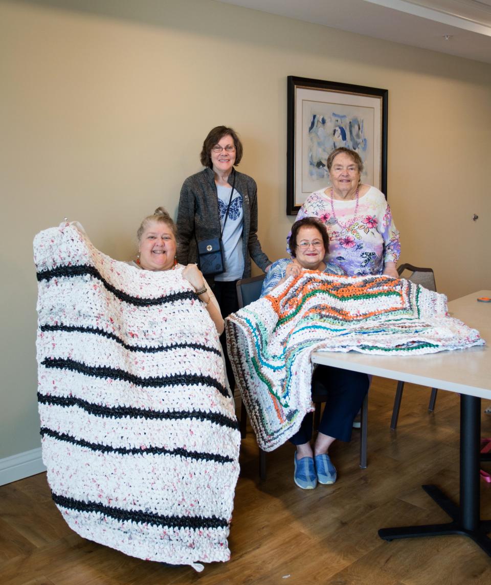 From left to right, Cathy Kownacki, Sharon Esche, Karen Damerville and Joyce Miller show off the mats they created out of plastic bags at Grand Living in West Des Moines.