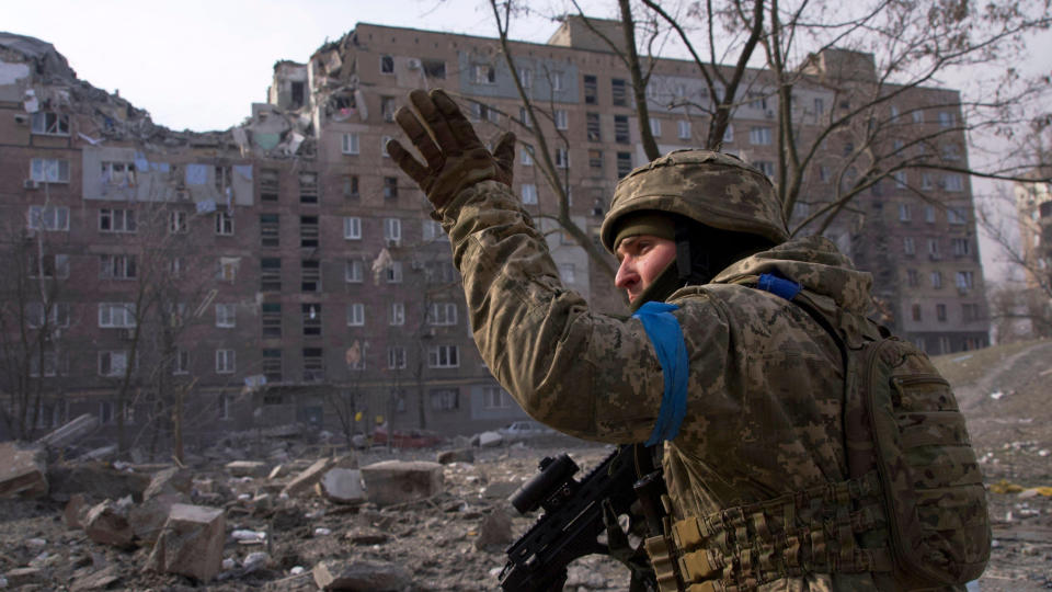 A Ukrainian soldier in front of a ruined building in Mariupol, Ukraine, taken from the documentary film 