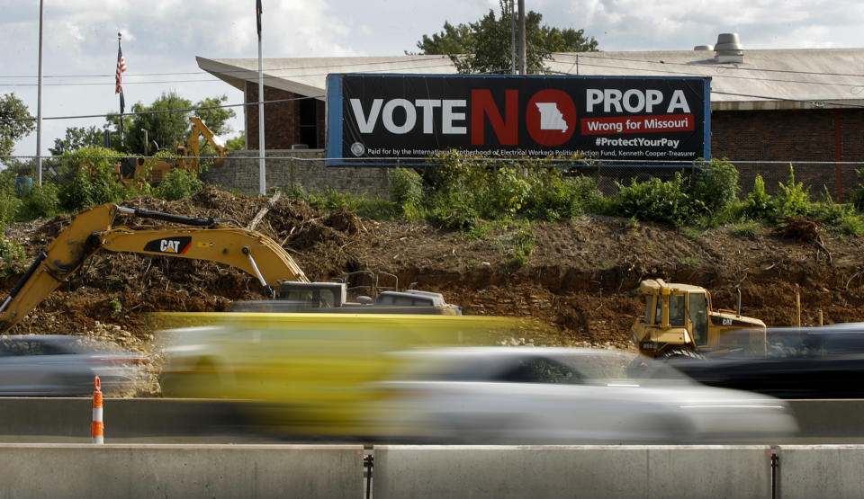 In this photo taken Wednesday, Aug. 1, 2018, motorists pass a sign against Proposition A in Kansas City, Mo. Missouri votes Tuesday, Aug. 7 on a so-called right-to-work law, a voter referendum seeking to ban compulsory union fees in all private-sector workplaces. (AP Photo/Charlie Riedel)