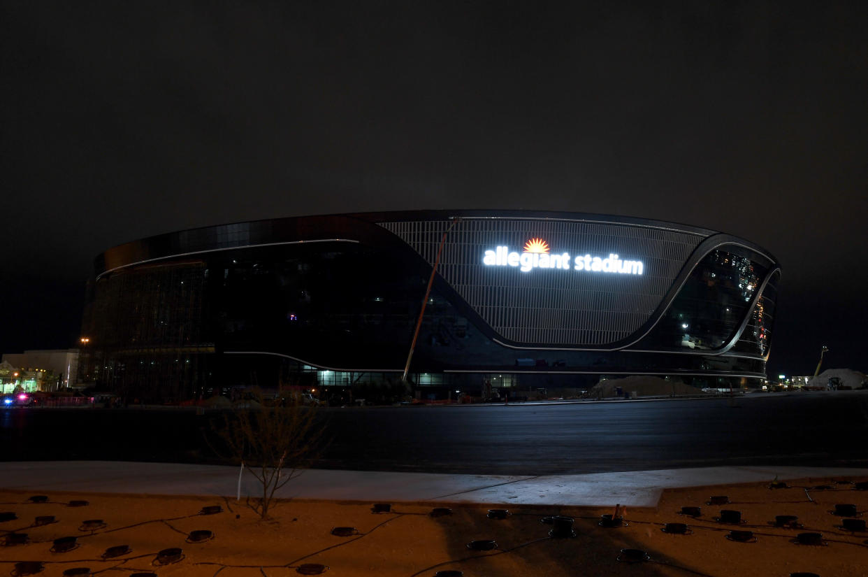 LAS VEGAS, NEVADA - APRIL 09:  Workers test the lighting on an exterior sign at Allegiant Stadium for the first time as construction continues on the USD 2 billion, glass-domed future home of the Las Vegas Raiders on April 9, 2020 in Las Vegas, Nevada. The Raiders and the UNLV Rebels football teams are scheduled to begin play at the 65,000-seat facility in their 2020 seasons.  (Photo by Ethan Miller/Getty Images)