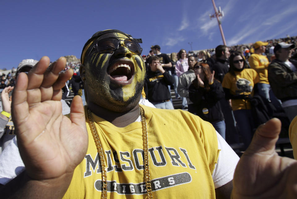 FILE - A Missouri fan who gave his name as Ronny M cheers during Missouri's Sun Bowl football game against Oregon State in El Paso, Texas, Friday, Dec. 29, 2006. College sports realignment will bring big challenges to fans who travel to see their teams on the road. (AP Photo/LM Otero, File)