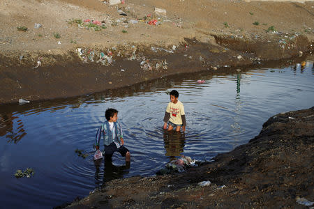 Children play in a water at a sewage pool amid an increase of cholera patients in Sanaa, Yemen March 17, 2019. Picture taken March 17, 2019. REUTERS/Khaled Abdullah
