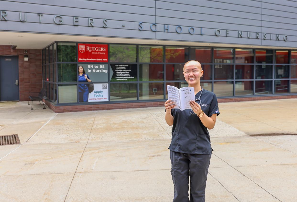 Stephanie Yuen holds a copy of her book "Stronger Together" outside Rutgers University's School of Nursing.