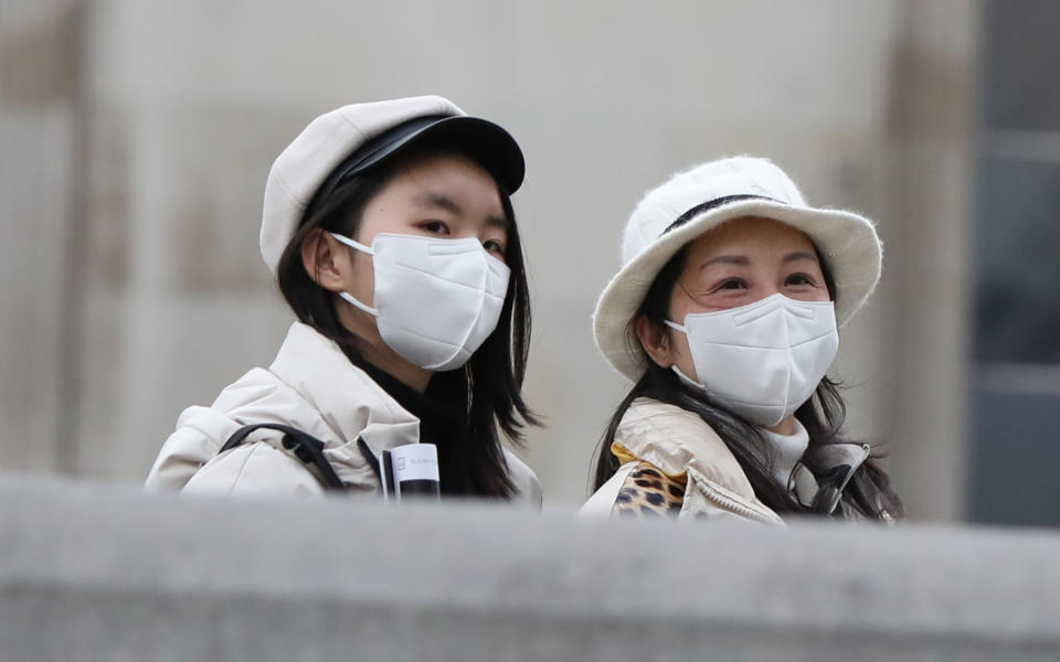 Two women walk through London's Trafalgar Square wearing protective facemasks on the day that Heath Secretary Matt Hancock said that the number of people diagnosed with coronavirus in the UK has risen to 51. (Photo by Luciana Guerra/PA Images via Getty Images)