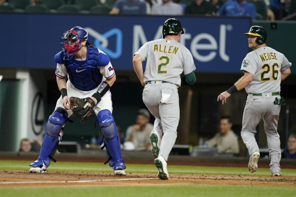 Texas Rangers catcher Sam Huff waits for the throw as Oakland Athletics' Nick Allen (2) and Sheldon Neuse (26) score on a Cristian Pache single during the fourth inning of a baseball game in Arlington, Texas, Tuesday, Sept. 13, 2022. (AP Photo/Tony Gutierrez)