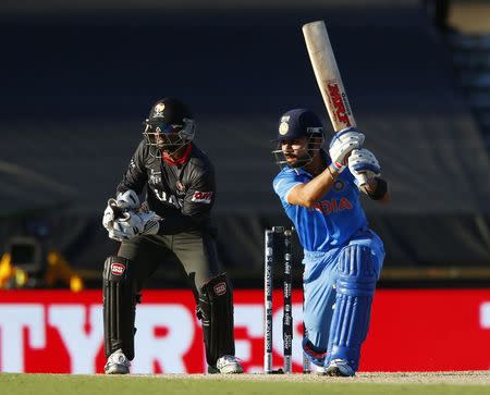 India's batsman Virat Kohli (R) plays a shot to point as United Arab Emirates' wicket keeper Swapnil Patil watches during their Cricket World Cup match in Perth, February 28, 2015. REUTERS/David Gray