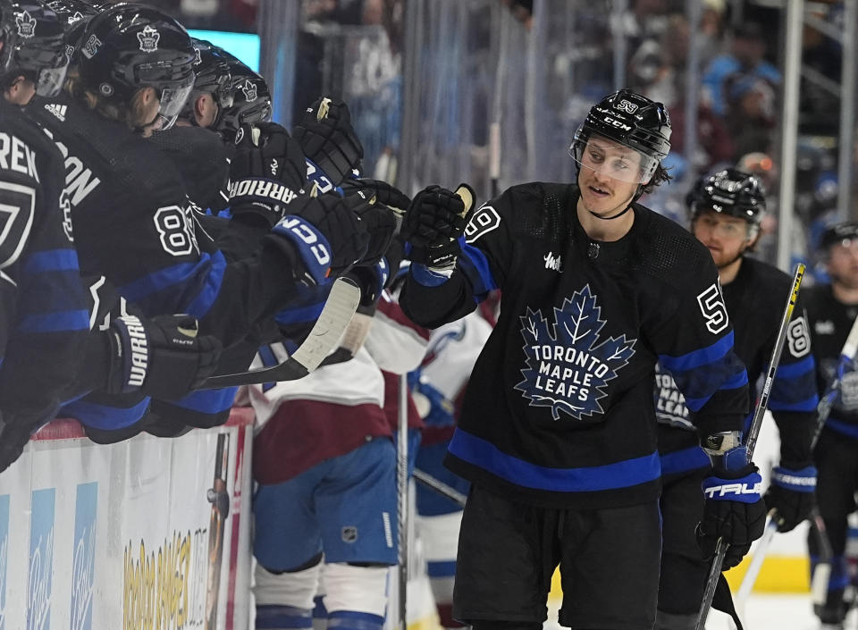 Toronto Maple Leafs left wing Tyler Bertuzzi, right, is congratulated as he passes the team box after scoring his thrid goal of the contest in the third period of an NHL hockey game against the Colorado Avalanche Saturday, Feb. 24, 2024, in Denver. (AP Photo/David Zalubowski)