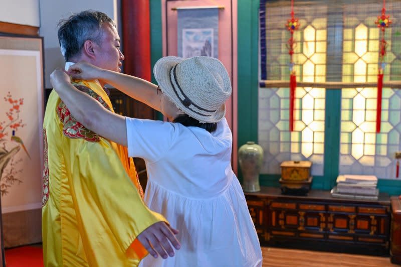 Kim Hyeong-jun, owner of the K-Drama Art Exhibition Hall in Yeoncheon, puts a period costume on a visitor. Photo by Thoams Maresca/UPI