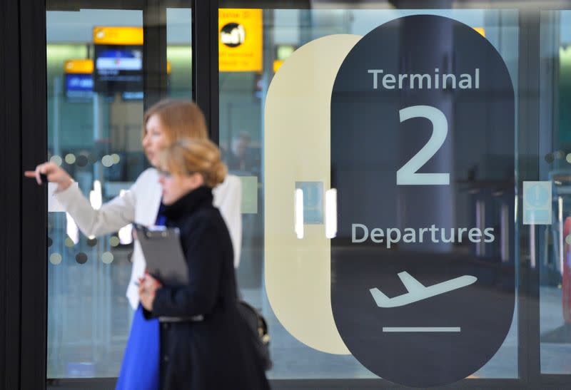 FILE PHOTO: Visitors are seen in a doorway at the departure area of the new 'Terminal 2: The Queen's Terminal' during a media event in Heathrow Airport, west London