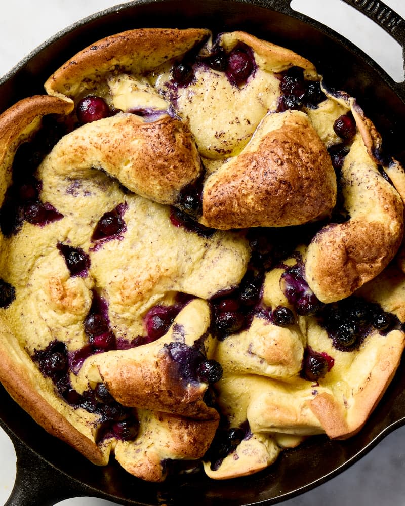 overhead shot of a lemon blueberry dutch baby pancake in a cast iron pan.