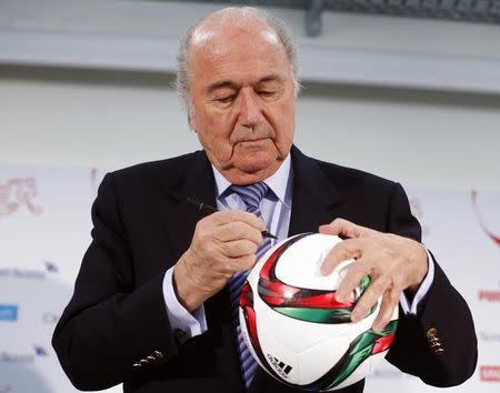 FIFA president Sepp Blatter signs autographs on a ball in Luzern March 27, 2015. REUTERS/Arnd Wiegmann