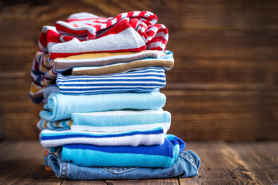 Stack of colorful children's clothes folded on a wooden floor