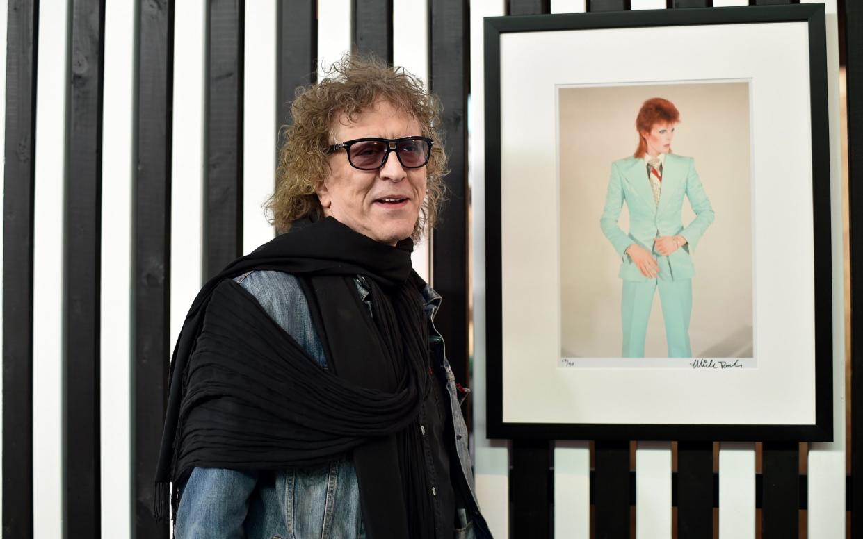 Mick Rock with one of his photographs of David Bowie in his exhibition Life on Mars in Toulouse in 2016 - Remy Gabalda/AFP/Getty