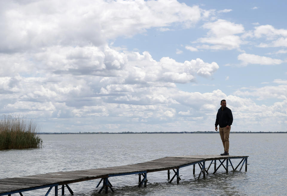 Mayor of Szigliget, Daniel Balassa stands on the pier over Lake Balaton in Szigliget, Hungary on May 18, 2021. Lake Balaton is the largest lake in Central Europe and one of Hungary's most cherished natural treasures. But some worry that the lake's fragile ecosystem and the idyllic atmosphere of the quaint villages dotted along its banks are in danger because of speculative developments. (AP Photo/Laszlo Balogh)