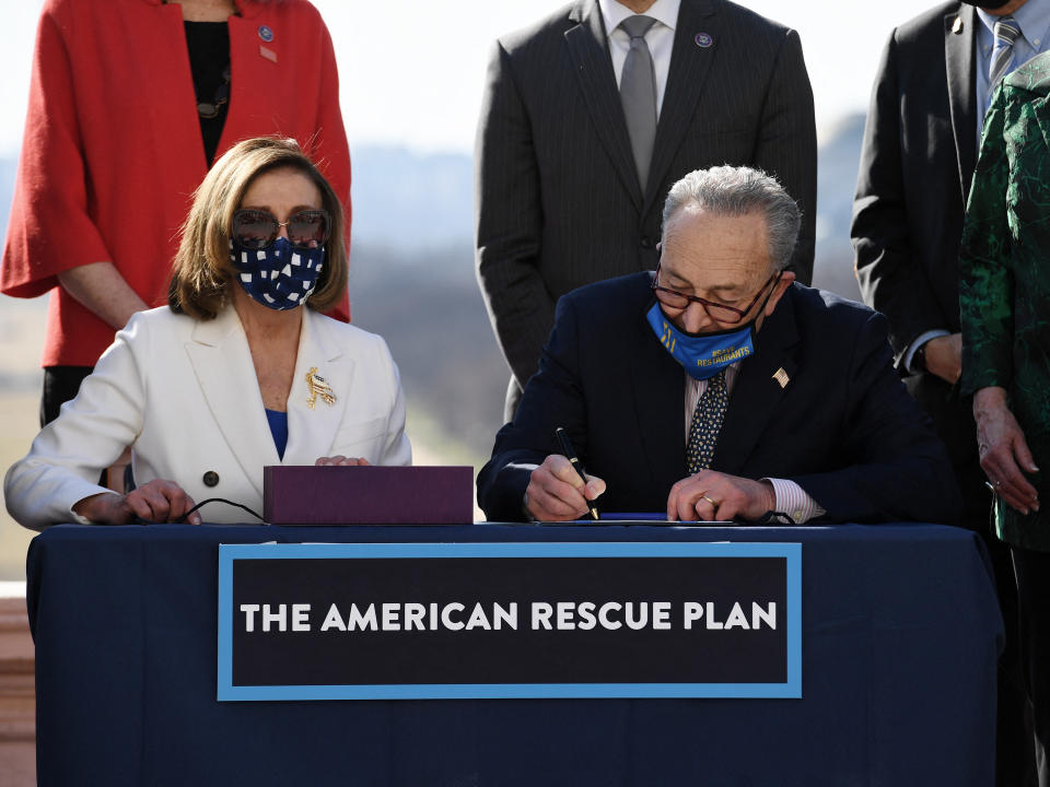 Speaker of the House Nancy Pelosi (L) and Senate Majority Leader Chuck Schumer sign the American Rescue Plan Act after the House Chamber voted on the final revised legislation of the $1.9 trillion Covid-19 relief plan, at the US Capitol on March 10, 2021 in Washington, DC. - The US Congress on Wednesday passed Joe Biden's enormous economic relief package, delivering a resounding victory for the US president and a desperately needed injection of cash to millions of families and businesses enduring the coronavirus pandemic. (Photo by OLIVIER DOULIERY / AFP) (Photo by OLIVIER DOULIERY/AFP via Getty Images)