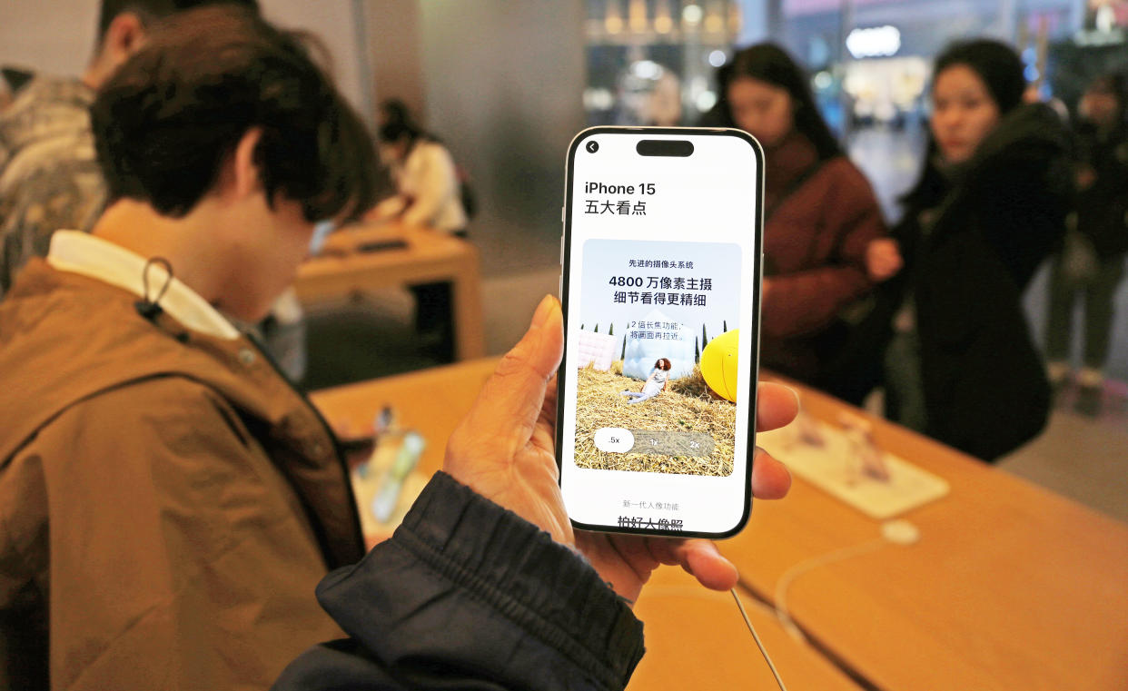 Customers experience the iPhone 15, powered by Qualcomm chips, at the Apple flagship store in Shanghai, China, on Nov. 12, 2023.