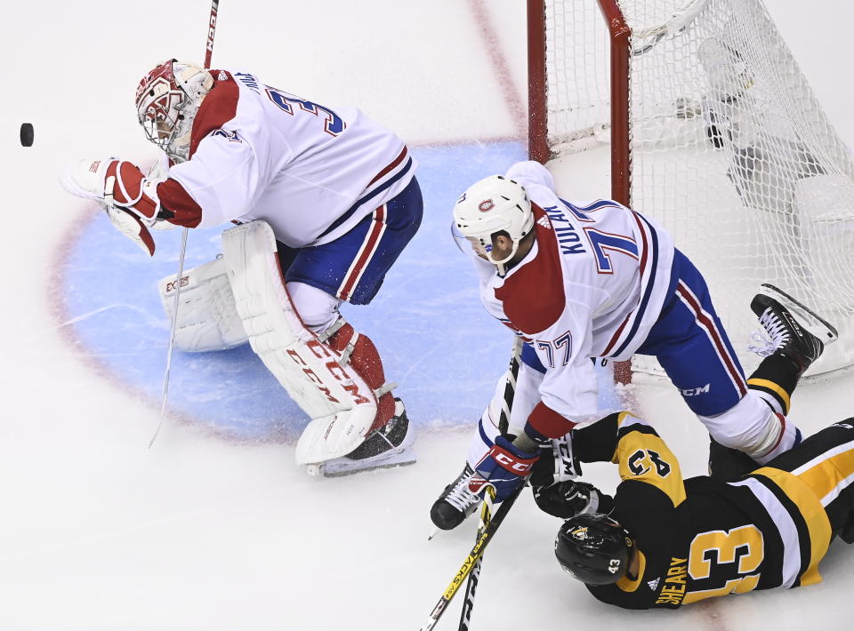 Montreal Canadiens goaltender Carey Price (31) makes a save as Canadiens defenseman Brett Kulak (77) takes down Pittsburgh Penguins left wing Conor Sheary (43) during second-period NHL Eastern Conference Stanley Cup playoff hockey game action in Toronto, Saturday, August 1, 2020. (Nathan Denette/The Canadian Press via AP)