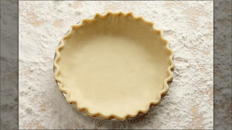raw pie crust crimped in tin