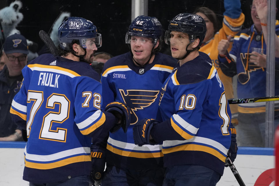 St. Louis Blues' Kasperi Kapanen, center, is congratulated by teammates Justin Faulk (72) and Brayden Schenn (10) after scoring the game-winning goal during overtime of an NHL hockey game against the New York Rangers Thursday, April 6, 2023, in St. Louis. (AP Photo/Jeff Roberson)